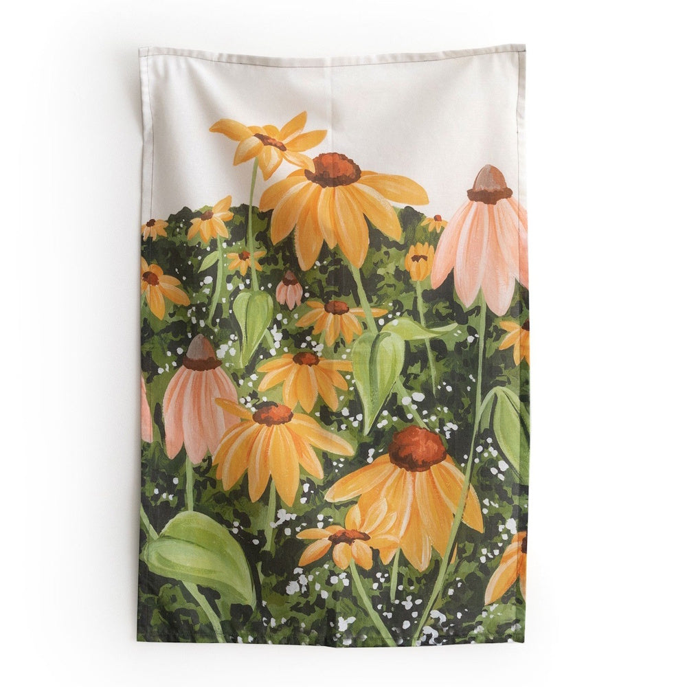A tapestry hanging on a wall featuring a painted field of yellow and pink coneflowers.