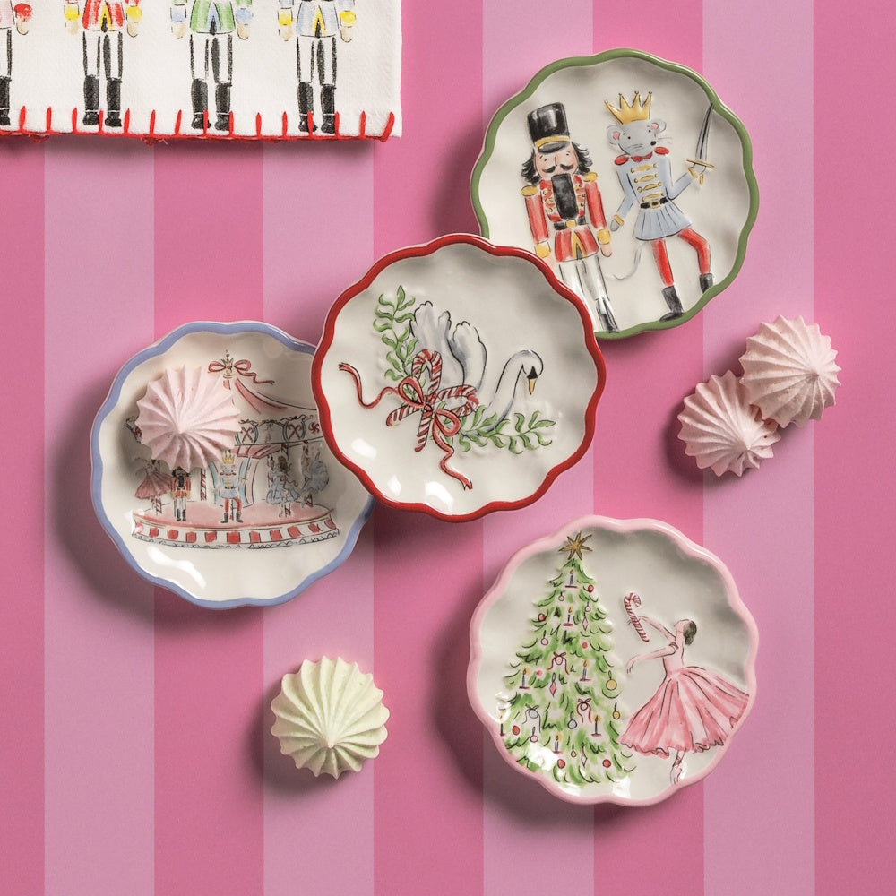 Lifestyle shot of the winter wonderland tidbit plates styled with meringue cookies on a pink striped background.