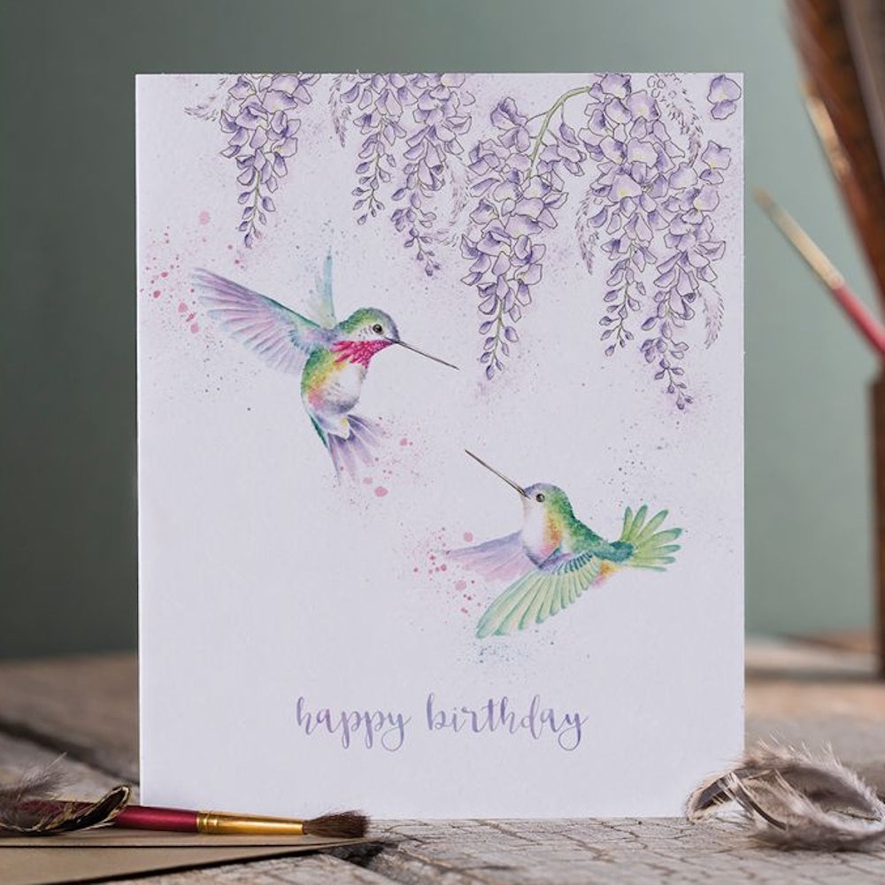 Watercolor wisteria birthday card featuring two hummingbirds and "happy birthday" text in purple script.