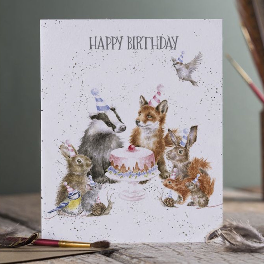 Illustration of woodland animals in party hats gathered around a birthday cake with "Happy Birthday" text.