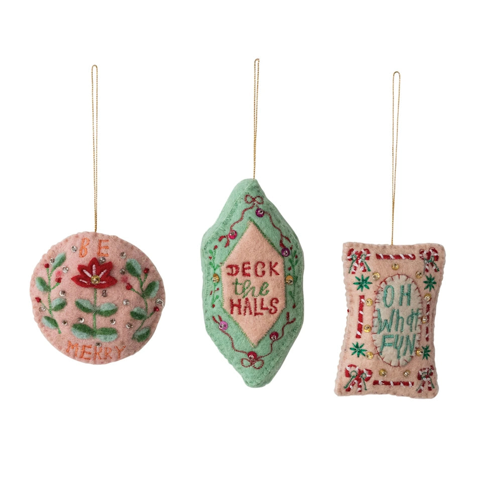 Front view of three assorted wool felt holiday ornaments featuring embroidered text, sequins, and beads.