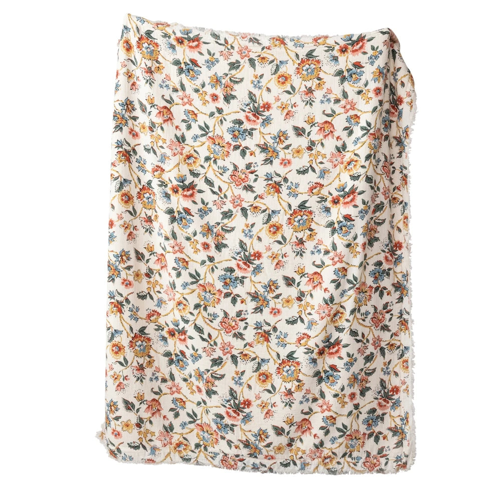 Cream floral throw blanket with vintage orange and blue wildflower pattern and frayed edges.
