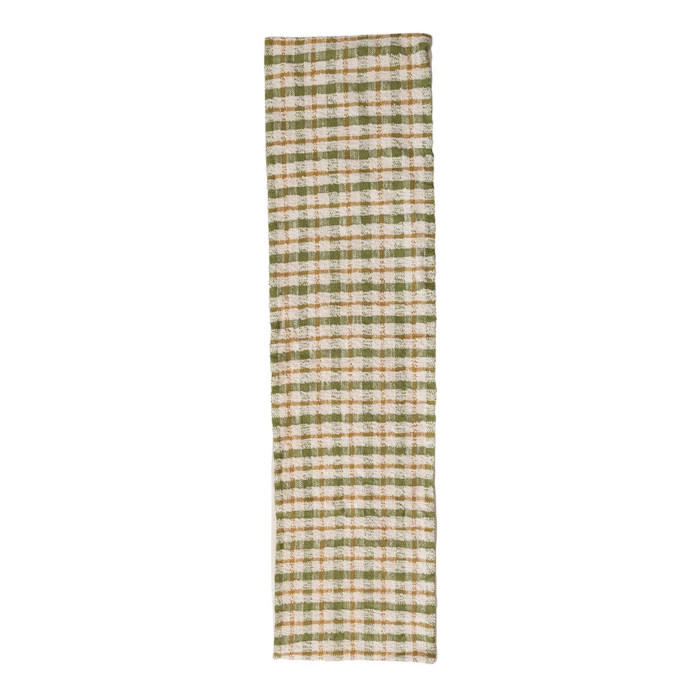 Green, tan, and cream checkered plaid woven cotton table runner isolated on a white background.