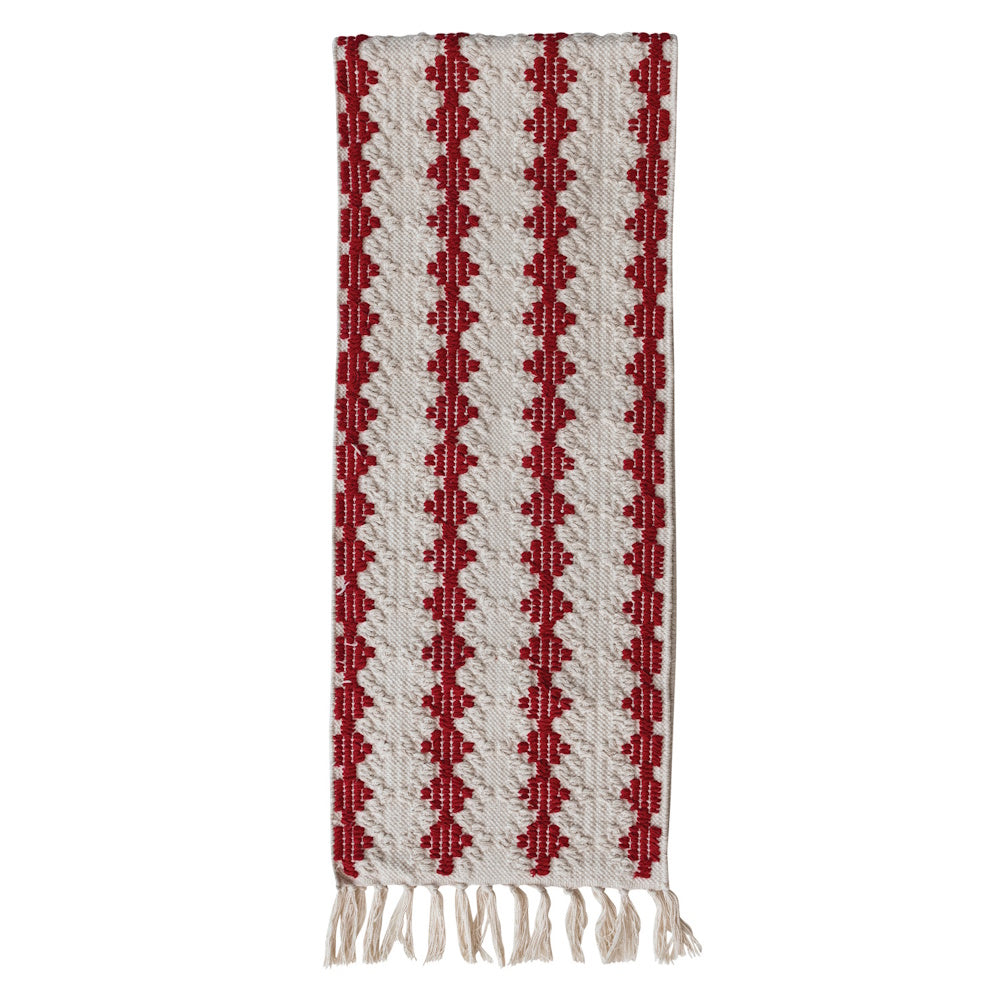 Woven white and red patterned table runner with fringe at the bottom edge.