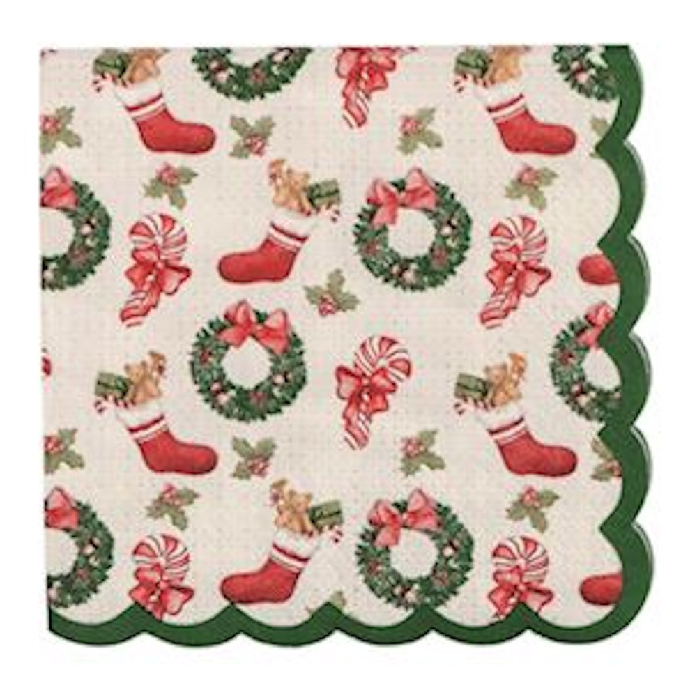 Square cocktail napkin with an all-over pattern of Christmas wreaths, stockings, candy canes, and holly, finished with green scalloped edges.