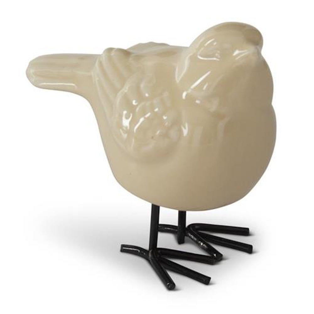 Cream-colored porcelain bird figurine with black metal legs and glossy finish on a white background.