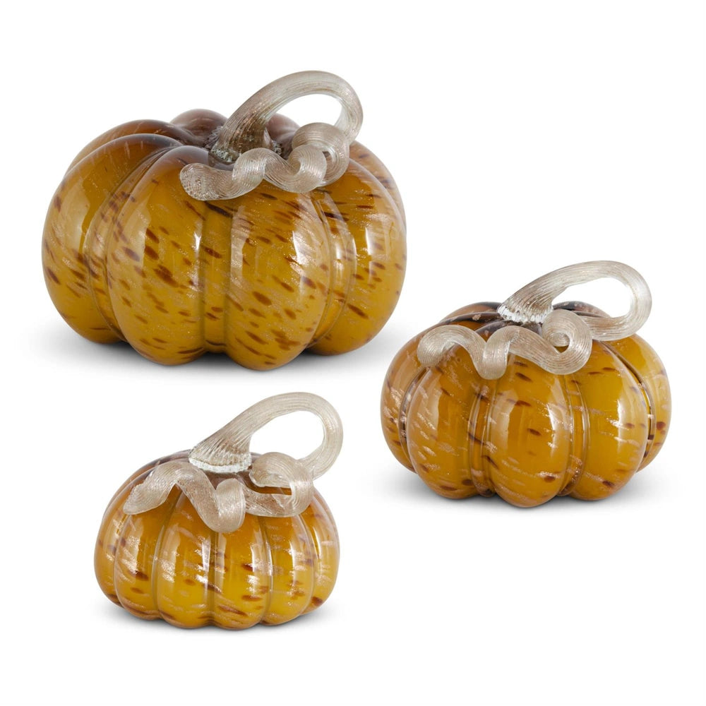 Set of three yellow speckled hand-blown glass pumpkins with twisted clear stems for autumn decor.